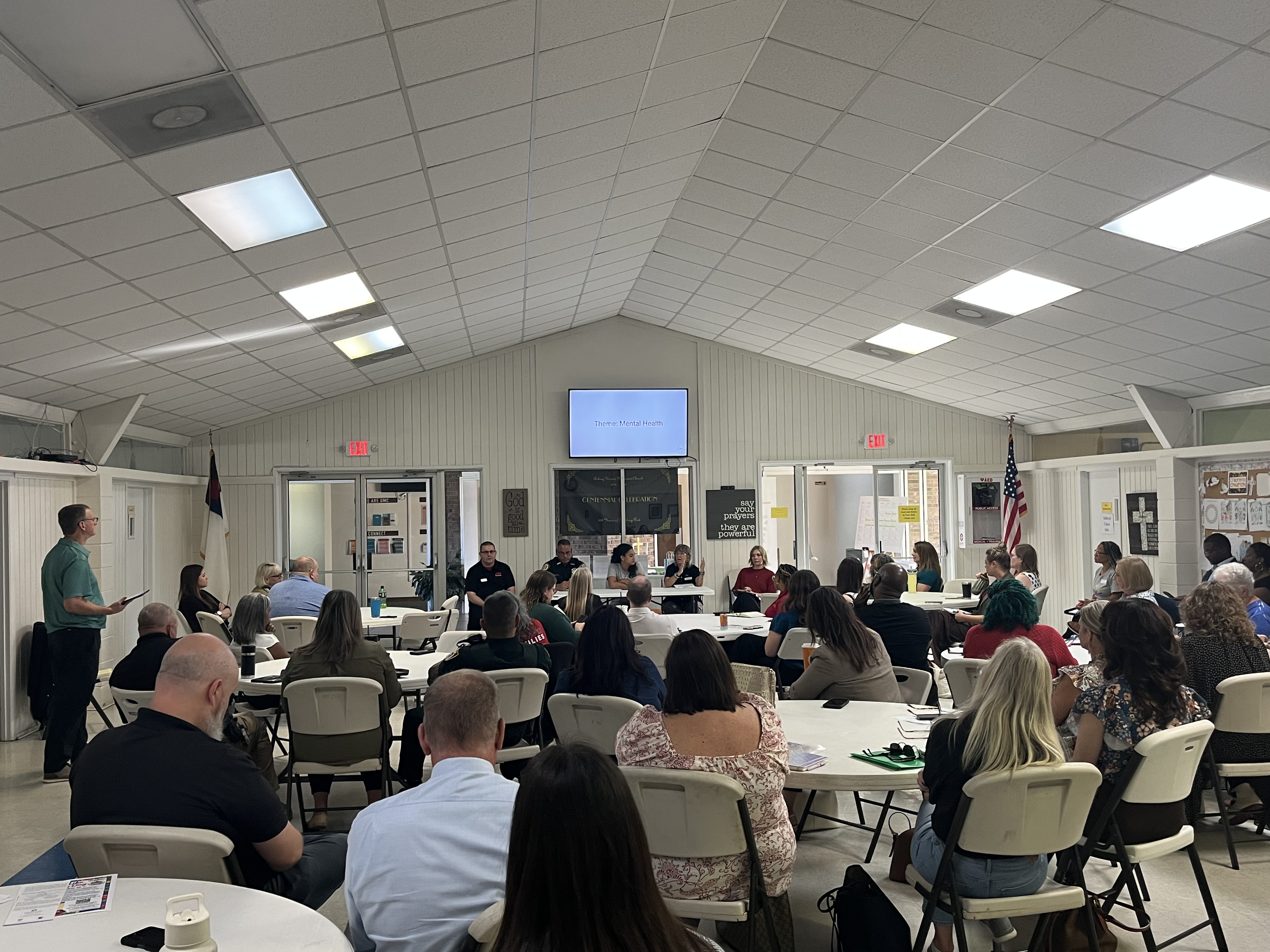 Clay SafetyNet partners gathered around tables at a community meeting focused on mental health